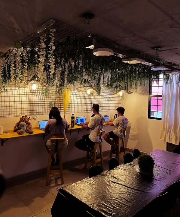 Personas trabajando con computadoras en un espacio con plantas