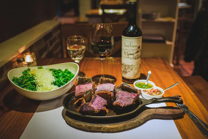 Plato de carne y vino en una mesa de restaurante